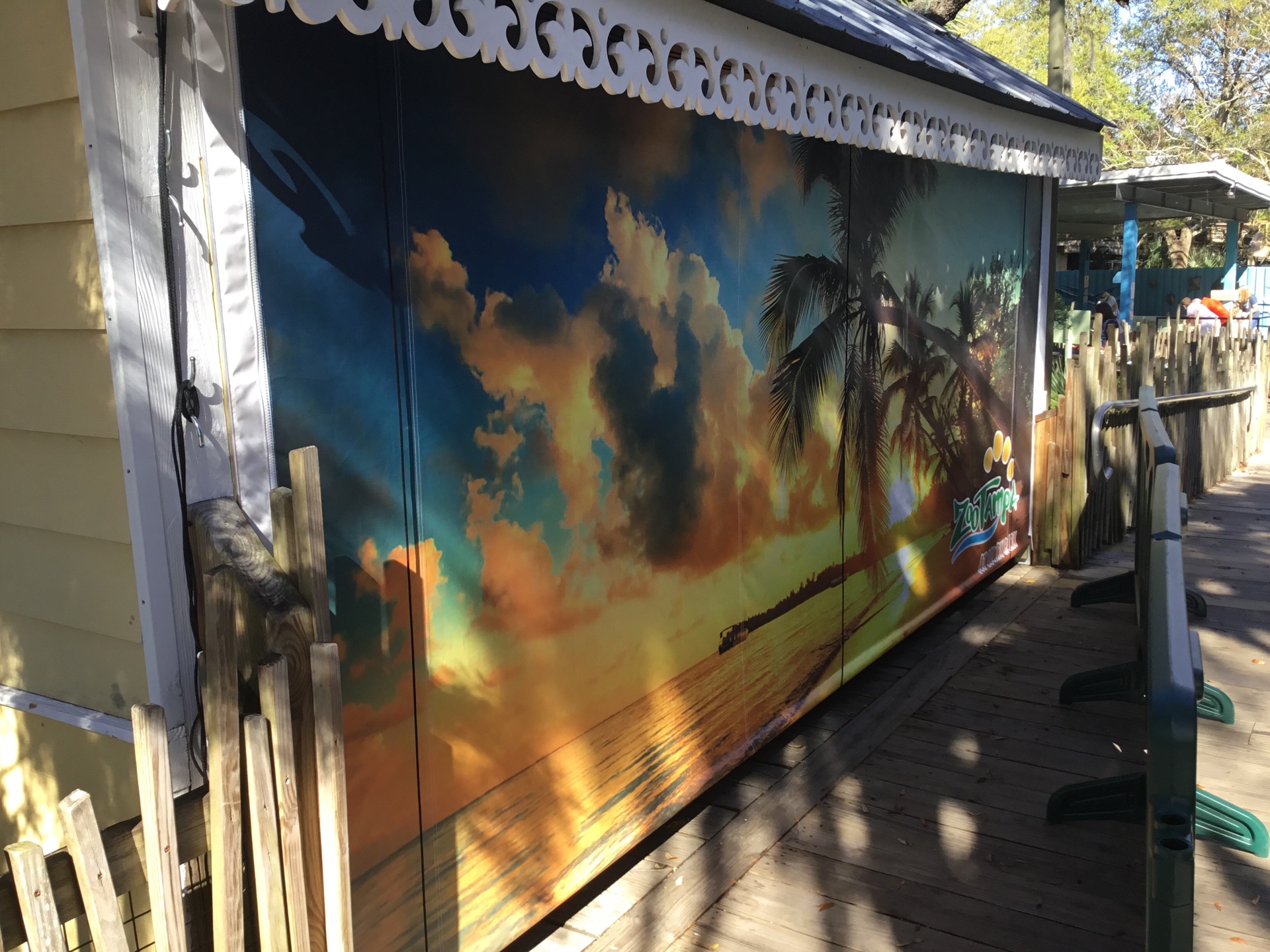 Custom-printed heavy-duty industrial curtain featuring a tropical sunset design, installed in a commercial outdoor setting at ZooTampa.