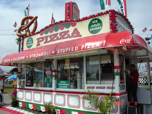 Red and white commercial awning with Coca-Cola branding on a pizza concession stand, featuring bold lettering and decorative accents.